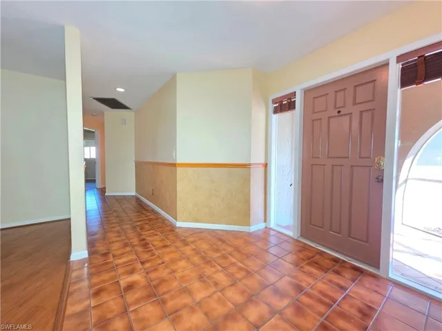Tiled foyer entrance featuring wainscoting and recessed lighting