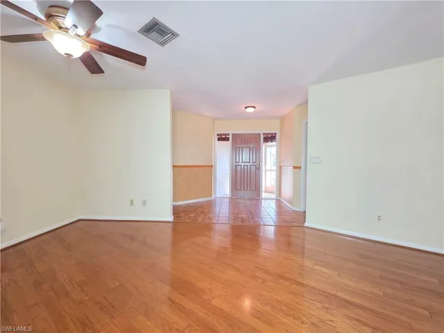Empty room featuring wood finished floors and a ceiling fan