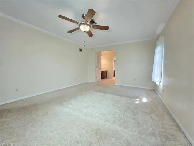 Unfurnished room with crown molding, ceiling fan, and light colored carpet