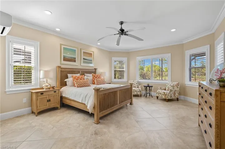 Bedroom with ornamental molding, ceiling fan, and light tile floors