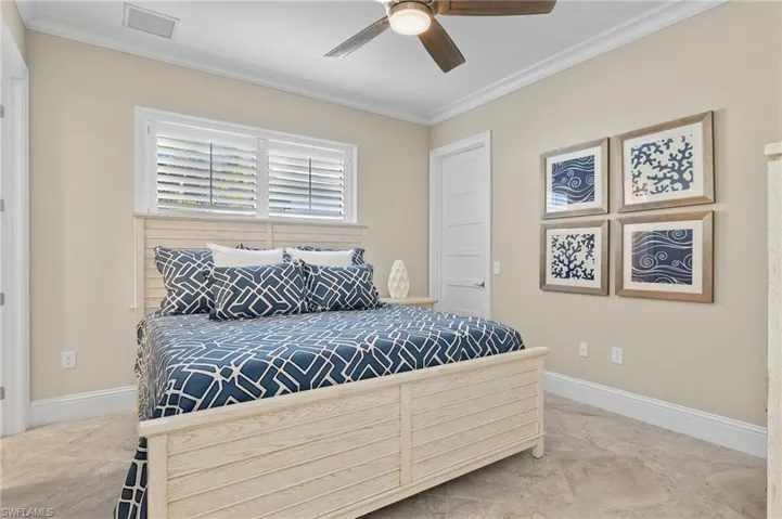 Bedroom with ceiling fan and crown molding