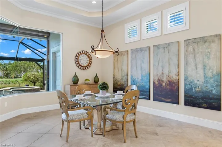 Dining room featuring a tray ceiling, tile flooring, and ornamental molding