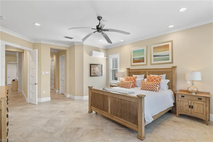 Tiled bedroom with crown molding, ceiling fan, and an AC wall unit