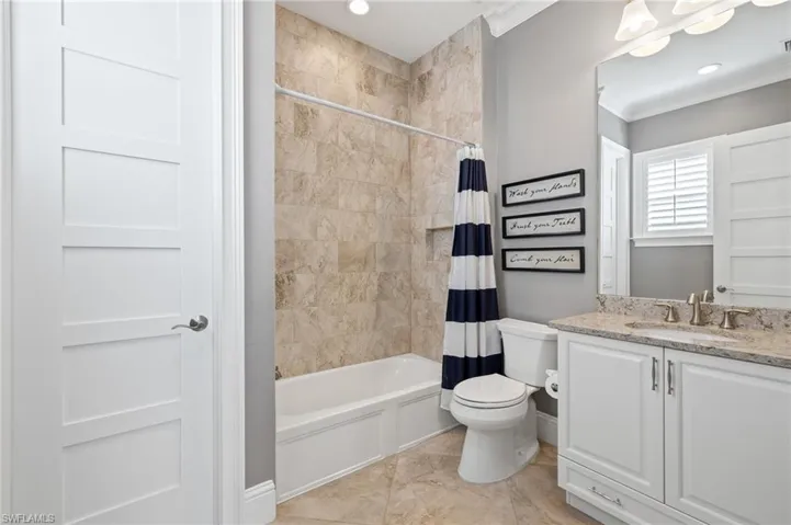 Full bathroom featuring tile floors, crown molding, shower / tub combo with curtain, and vanity
