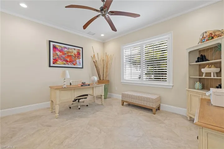 Tiled office space with crown molding and ceiling fan