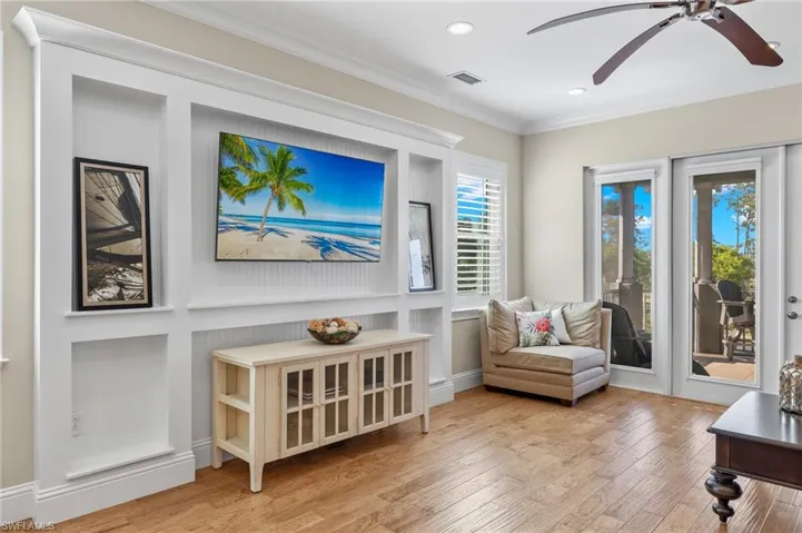 Living area upstairs with light hardwood / wood-style floors, ornamental molding, and ceiling fan