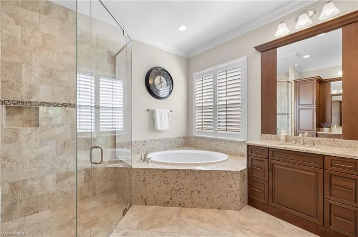 Bathroom with a healthy amount of sunlight, oversized vanity, separate shower and tub, and tile floors