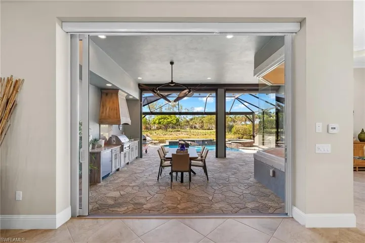 Dining area with a notable chandelier, tile flooring, and floor to ceiling windows