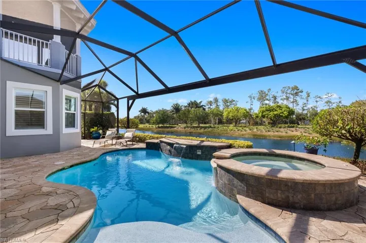 View of swimming pool featuring glass enclosure, an in ground hot tub, and a patio area