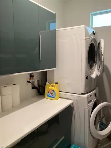 Washroom featuring stacked washer / drying machine