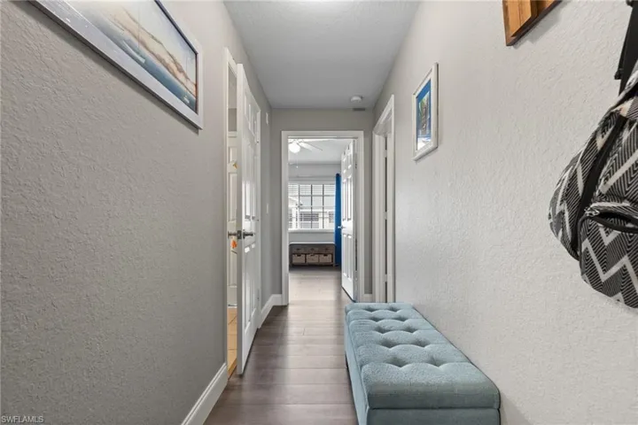 Corridor featuring dark hardwood / wood-style flooring and a textured ceiling