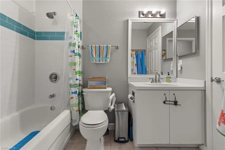 Full bathroom featuring vanity, toilet, tile patterned flooring, and shower / bath combo with shower curtain