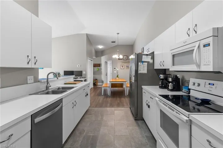 Kitchen with sink, white cabinets, and appliances with stainless steel finishes