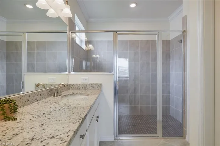 Bathroom with vanity, a shower stall, and tile patterned flooring