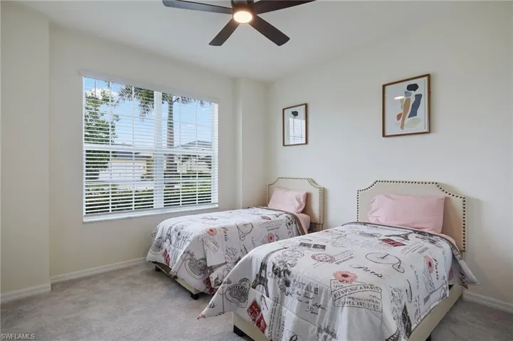 Carpeted bedroom featuring baseboards and a ceiling fan