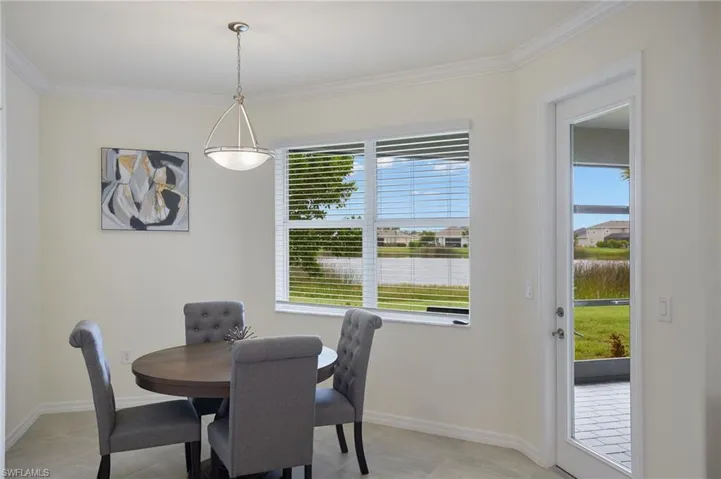 Dining area featuring ornamental molding and light tile patterned flooring