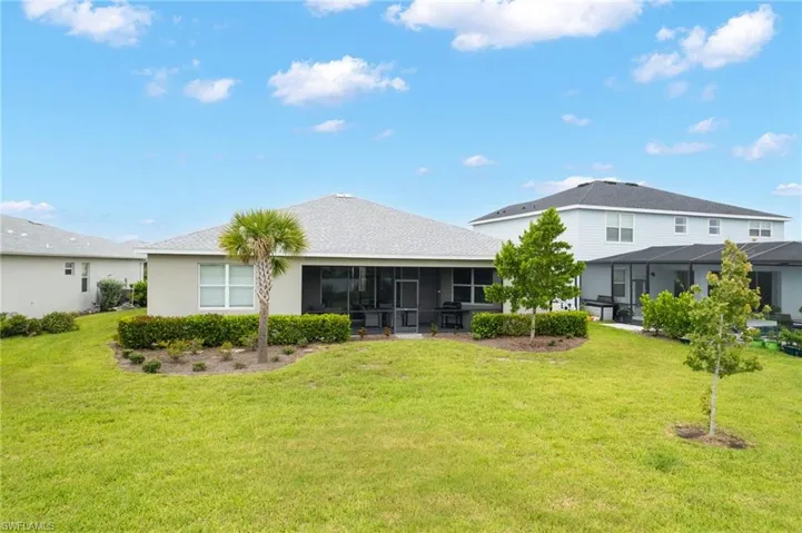 Back of property with a lawn and a sunroom