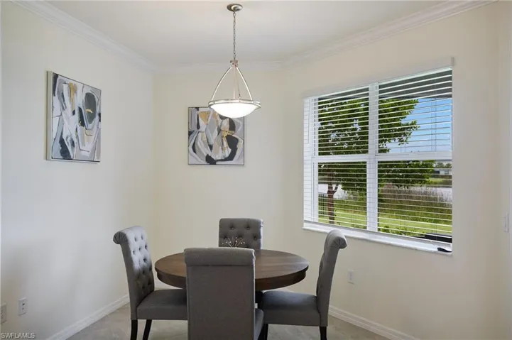Dining room featuring healthy amount of natural light, crown molding, and tile patterned floors