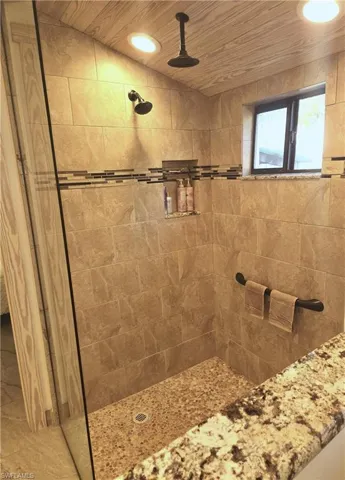 Bathroom with tiled shower and wood ceiling