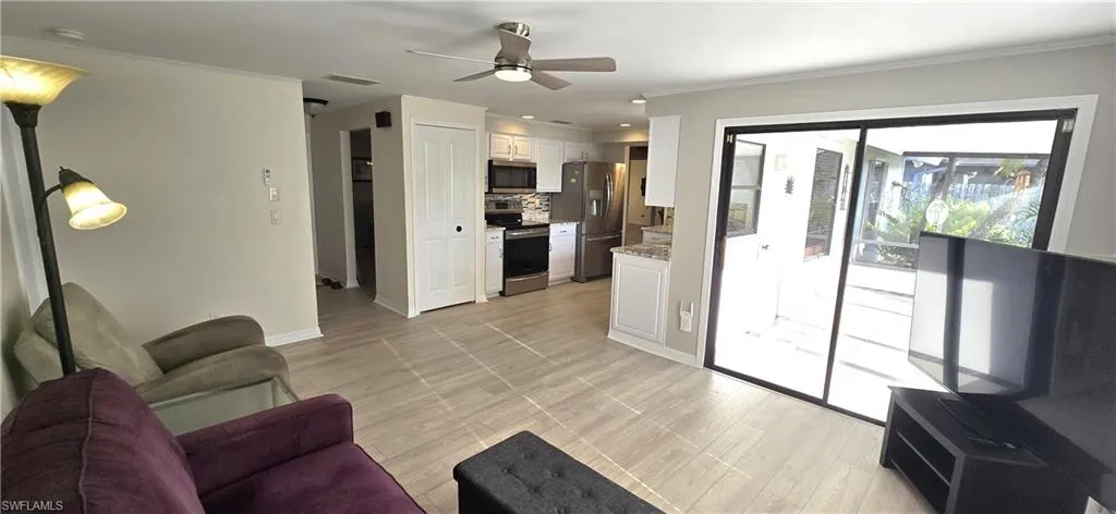 Living room with ceiling fan, ornamental molding, and recessed lighting