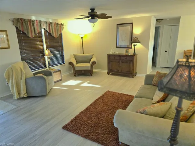 Living area featuring light wood-type flooring and a ceiling fan