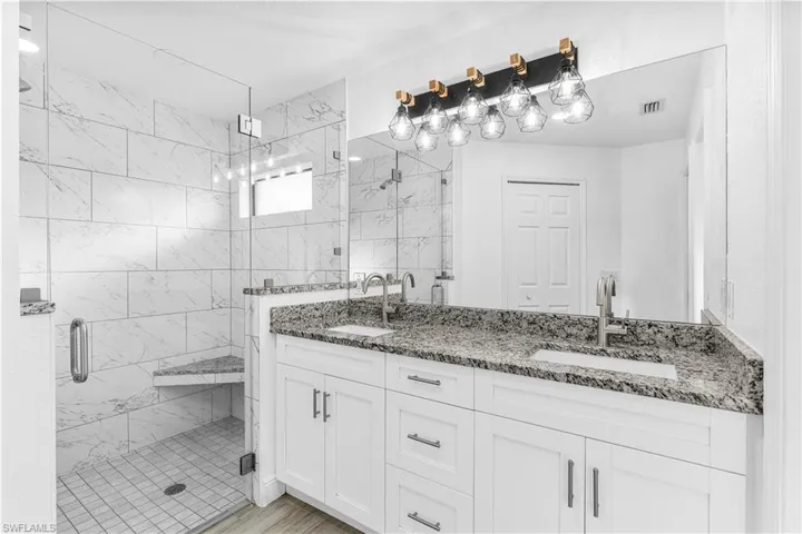 Bathroom with hardwood / wood-style flooring, vanity, and a shower with shower door