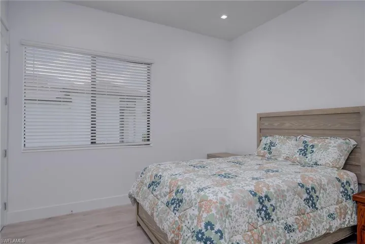Bedroom with wood finished floors and recessed lighting