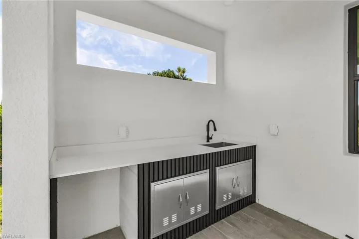Bar area featuring a sink and wood finish floors