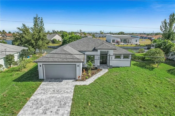 View of front of home featuring roof with shingles, a residential view, and stucco siding