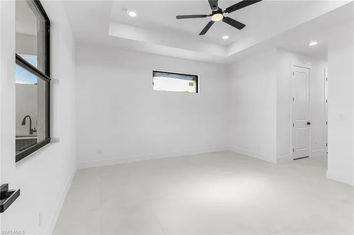 Unfurnished room featuring recessed lighting, ceiling fan, and a raised ceiling