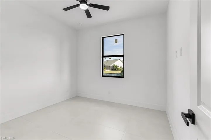 Empty room with baseboards and a ceiling fan