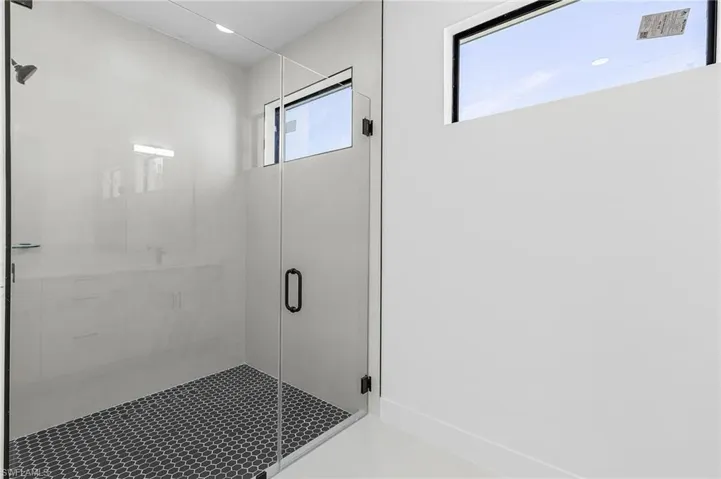 Full bathroom featuring a stall shower and baseboards