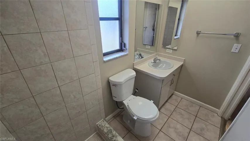 Full bath with vanity and light tile patterned floors