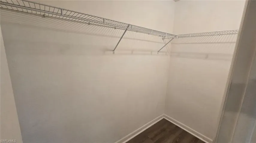 Walk in closet featuring dark wood-type flooring