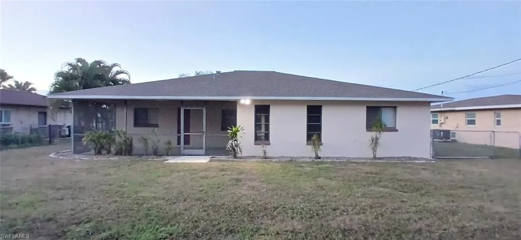 Rear view of property with a sunroom and stucco siding