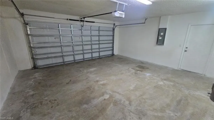 Garage featuring electric panel and a garage door opener