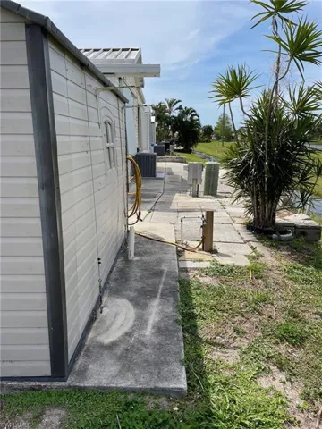 View of side of property with a patio and central AC