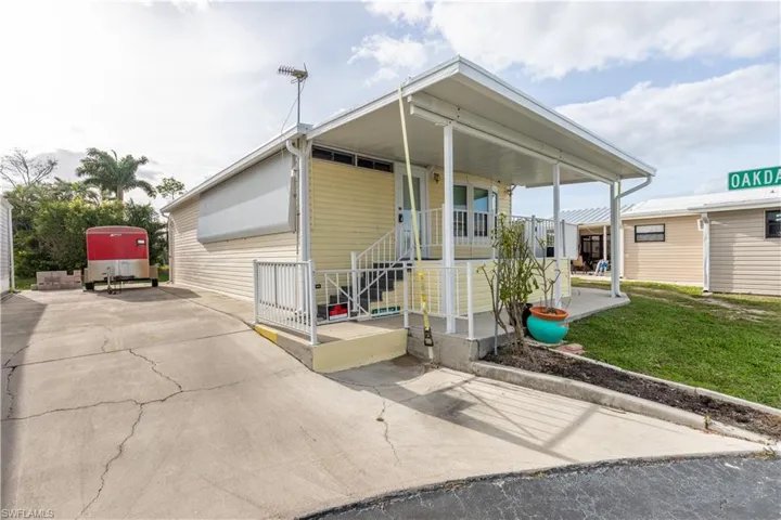 Manufactured / mobile home featuring a porch and a front lawn