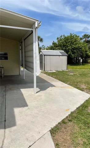 View of patio with a carport and a shed