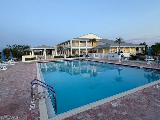 Community pool with a patio area and view of clubhouse
