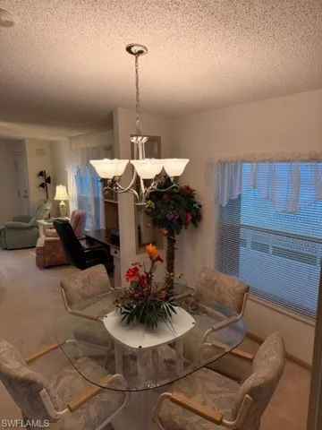 Dining area featuring carpet floors and a textured ceiling