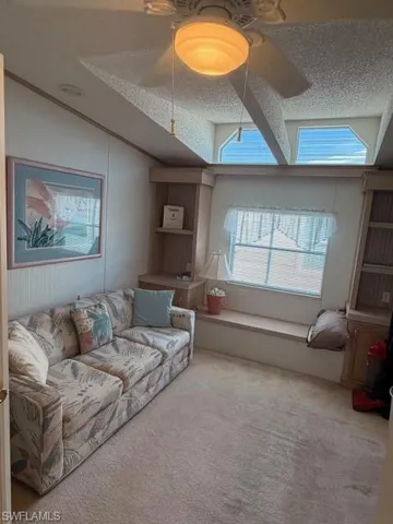 Carpeted Den featuring a ceiling fan
