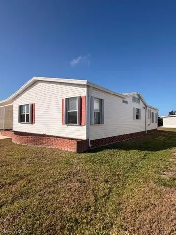 View of side of home featuring a lawn