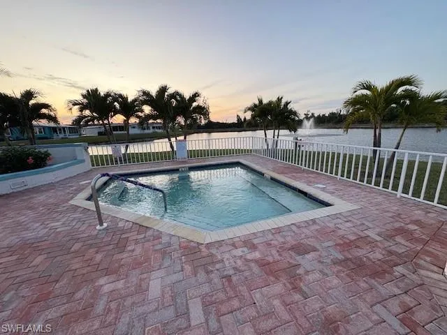 View of hot tub with view of fountain in private pond, with patio surround