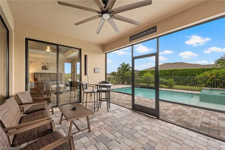 Screened lanai with paver flooring, ceiling fan, and sliding glass door access to the interior
