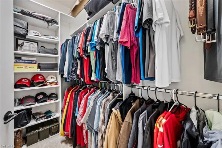 Built-in closet shelving, dual hanging rods, and integrated belt storage