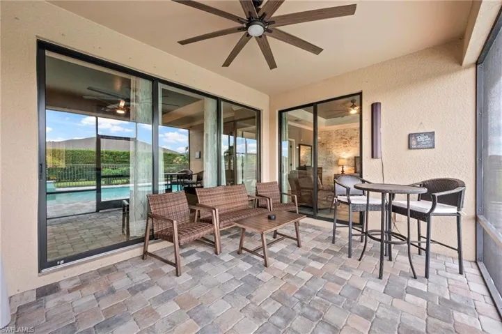 Screened patio with a paver surface, ceiling fan, and large sliding glass doors