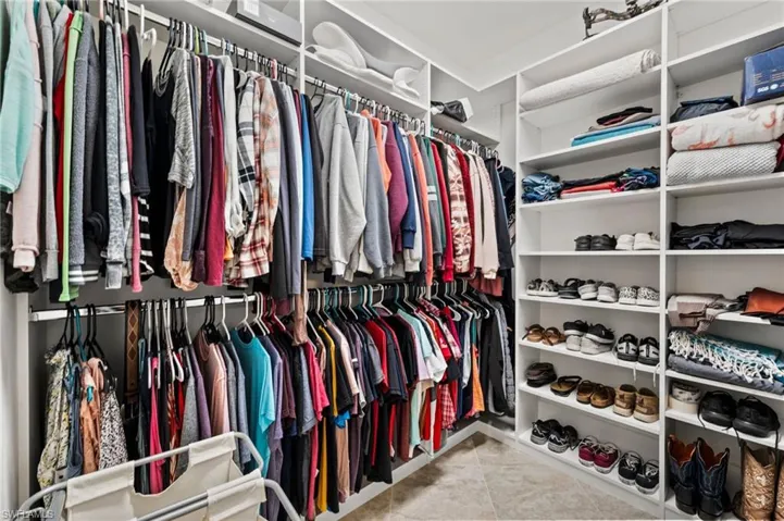 Custom closet with extensive shelving, multiple hanging rods, and an organized storage system