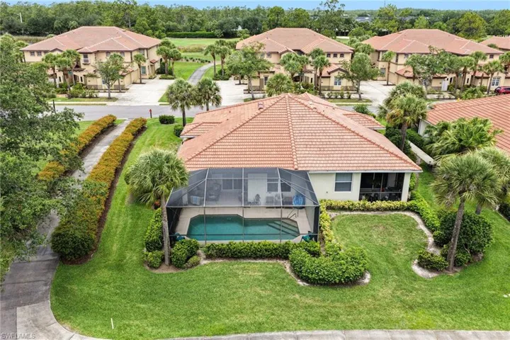 Property exterior featuring a screened-in pool, terracotta tile roof, and a mature palm tree