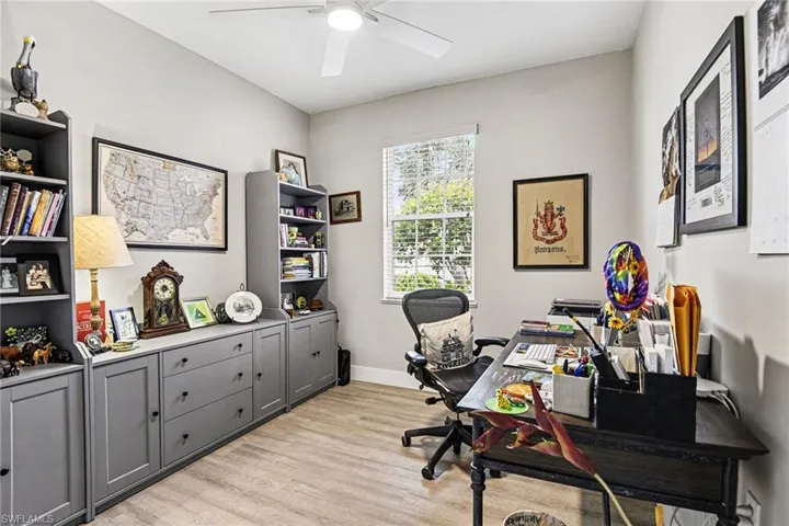 Spacious room featuring light wood-finish flooring, a ceiling fan, and a window with horizontal blinds